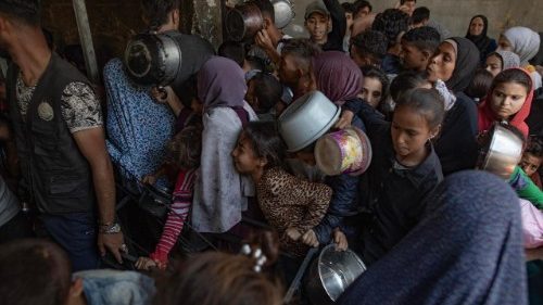 Centenas de deslocados palestinos tentam receber alimentos na "Sokar Charity Kitchen" na Cidade de Gaza